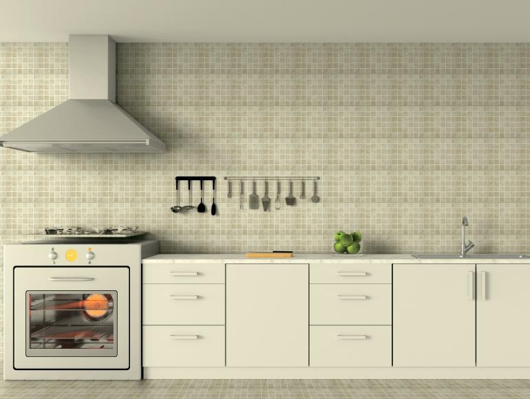 Minimalist I kitchen design with beige mosaic tiles, white cabinets, modern appliances, and a sleek ventilation hood.